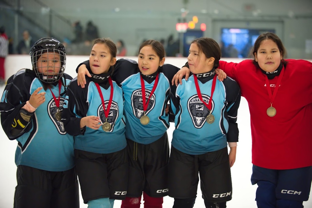 Jeunes filles de l'école Kanatamat fières de leur victoire lors d'un tournoi d'hockey.